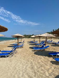 a group of chairs and umbrellas on a beach at Flat Panorama Sea View Studio for Couples Vrachos in Preveza