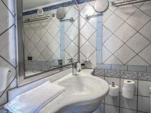 a white bathroom with a sink and a mirror at Niriides Studios & Apartments in Kithnos +48 photos