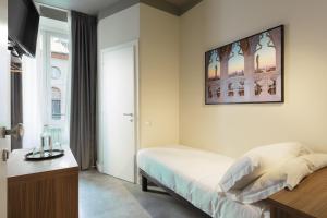 a bedroom with a bed and a television on the wall at Hotel 22 Marzo in Milan