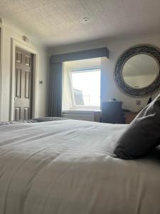 a bedroom with a large white bed and a window at Royal Victoria Hotel Snowdonia in Llanberis