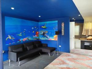 a blue room with a couch and an aquarium at Residence Las Lajas in Las Lajas
