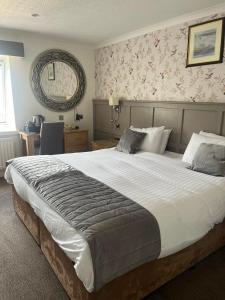 a bedroom with a large bed and a table at Royal Victoria Hotel Snowdonia in Llanberis