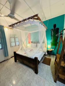 a bedroom with a large bed with a canopy at Babalao Bungalows in Nungwi