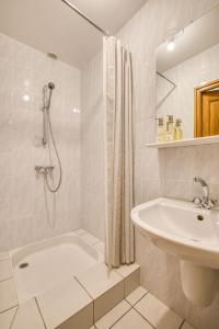 a white bathroom with a tub and a sink at Auberge du pont de l'Abîme in Gruffy
