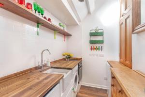 a kitchen with white walls and wooden counters and a sink at Alnwick Book Nook - dog friendly in Alnwick +10 photos