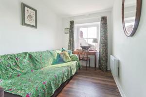 a living room with a green couch and a table at Alnwick Book Nook - dog friendly in Alnwick