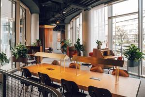 a conference room with tables and chairs and windows at Revo Munich in Munich