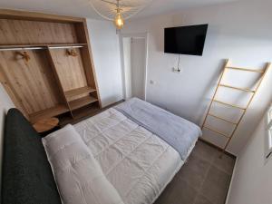 卡勒达德福斯特Hoy Caleta Apartments的一间小卧室,配有一张床和一台平面电视