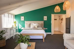 a green bedroom with a bed and a green wall at Ocean-View Studio Apartment, Hermanus Waterfront - Apt 8 in Hermanus +36 photos