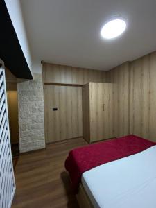 a bedroom with a large bed with a red blanket at stefanias apartment in Tirana