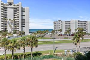 an empty street with palm trees in front of buildings at Oceanwalk 13-406 in New Smyrna Beach