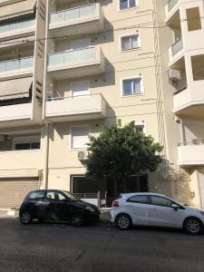 dwa samochody zaparkowane przed budynkiem w obiekcie 3BR Prime APT a breath away from the Acropolis! w Atenach