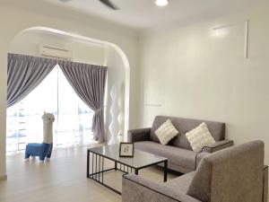 un soggiorno con un divano e un tavolo di Sekinchan 2008 Home 悦客 盐系奶咖风民宿 a Sekincan