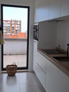 a kitchen with a view of a building from a window at zonnig vernieuwd penthouse dicht bij het strand in Knokke-Heist