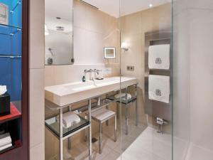 a bathroom with a sink and a mirror at Sofitel Legend The Grand Amsterdam in Amsterdam