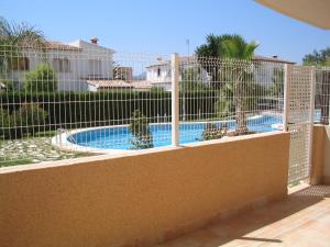 a fence around a swimming pool in a yard at Apartamento Familiar Jávea en Planta Baja in Jávea +16 photos