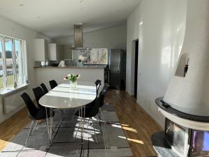 a kitchen and dining room with a white table and chairs at Villa Solsa in Nynäshamn +23 photos