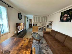 a living room with a couch and a table at Appartement khezia in Champigny-sur-Marne