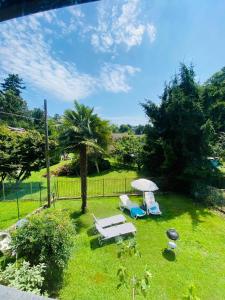 ルイーノにあるCasa dell’Artistaのラウンジチェア2脚とパラソル1本付きの庭