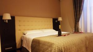 Un dormitorio con una cama con una botella de vino. en Hotel Nautilus en Roma