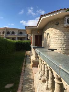 una casa con una pared de piedra delante de ella en North Coast Marwa Resort Villa, en Dawwār ‘Abd Allāh