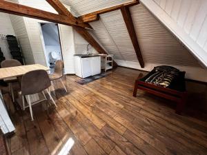 an attic room with a wooden floor and a table at Kalinka 90766 Fürth in Fürth