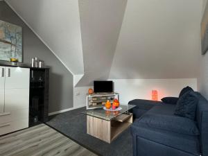 a living room with a blue couch and a table at Ferienwohnung Lias in Südbrookmerland