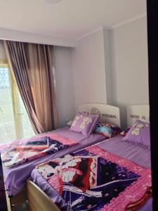 two twin beds in a room with a window at بورتو جولف مارينا Porto Golf Marina in El Alamein
