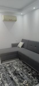 a gray couch in a room with a white wall at بورتو جولف مارينا Porto Golf Marina in El Alamein