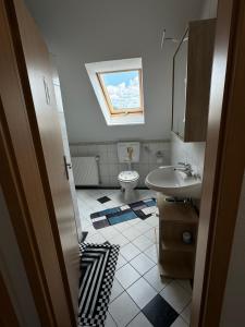a bathroom with a sink and a toilet and a window at Ferienwohnung Lias in Südbrookmerland