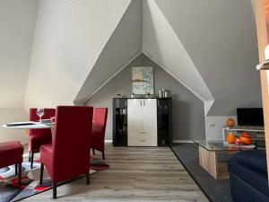 a living room with a table and a refrigerator at Ferienwohnung Lias in Südbrookmerland