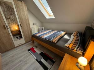 a small bedroom with a bed and a skylight at Ferienwohnung Lias in Südbrookmerland