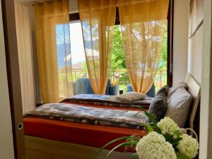 a bedroom with a bed and a large window at Casa dell’Artista in Luino