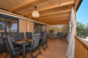 a patio with a table and chairs on a deck at Kamp Oaza Lučica in Drage +33 photos