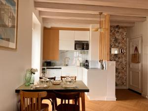 a kitchen with a table with wine glasses on it at Appartement vue Loire - Chez Lulu la Nantaise in Rezé +14 photos