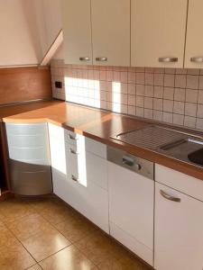 a kitchen with white cabinets and a sink at NEU Ferienwohnung im Naherholungs u Seengebiet in Bruck in der Oberpfalz