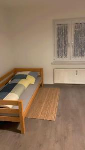 a bedroom with a wooden bed in a room at NEU Ferienwohnung im Naherholungs u Seengebiet in Bruck in der Oberpfalz