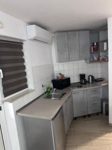 une petite cuisine avec un évier et un micro-ondes dans l'établissement Studio Apartman M&M, à Split