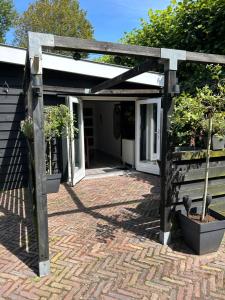 a wooden pergola with two potted plants on a patio at Beach lodge in Zandvoort