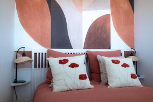 - une chambre avec des oreillers rouges et blancs sur un lit dans l'établissement Le coquet à 20min de Paris et de l'aéroport d'Orly, à Juvisy-sur-Orge