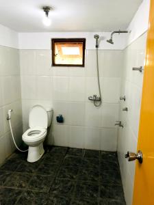 a bathroom with a toilet and a window at Cafe Tangola Home Stay in Tangalle