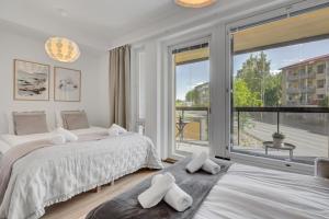 a bedroom with two beds and a large window at Bellarova Apartments Lehtikatu in Rovaniemi