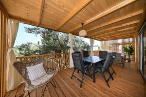 a wooden deck with a table and chairs on it at Kamp Oaza Lučica in Drage