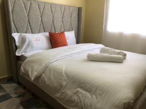 ナイバシャにあるMoi South Lake, Naivasha 2 & 3 Bedroom Apartment Near Lake Naivasha Resortのベッド1台(タオル2枚付)