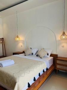 a bedroom with a large bed with two pillows at Volcano Garden in Kubupenlokan