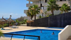 twee personen in een zwembad in een hotel bij SolDosMares Apartmentos in La Manga del Mar Menor