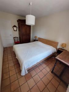 a bedroom with a white bed and a table at Haus im Naturpark Luberon in Grambois +8 photos