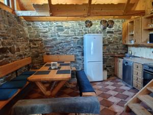 a kitchen with a wooden table and a refrigerator at Chata Jednička in Ruda na Moravě