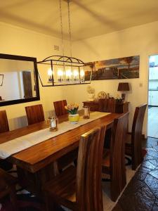 Un comedor con mesa y sillas de madera. en Hodson Villa, en Harare