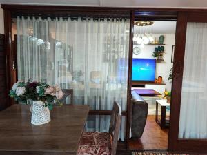 Un jarrón de flores sobre una mesa en una sala de estar. en Hodson Villa, en Harare